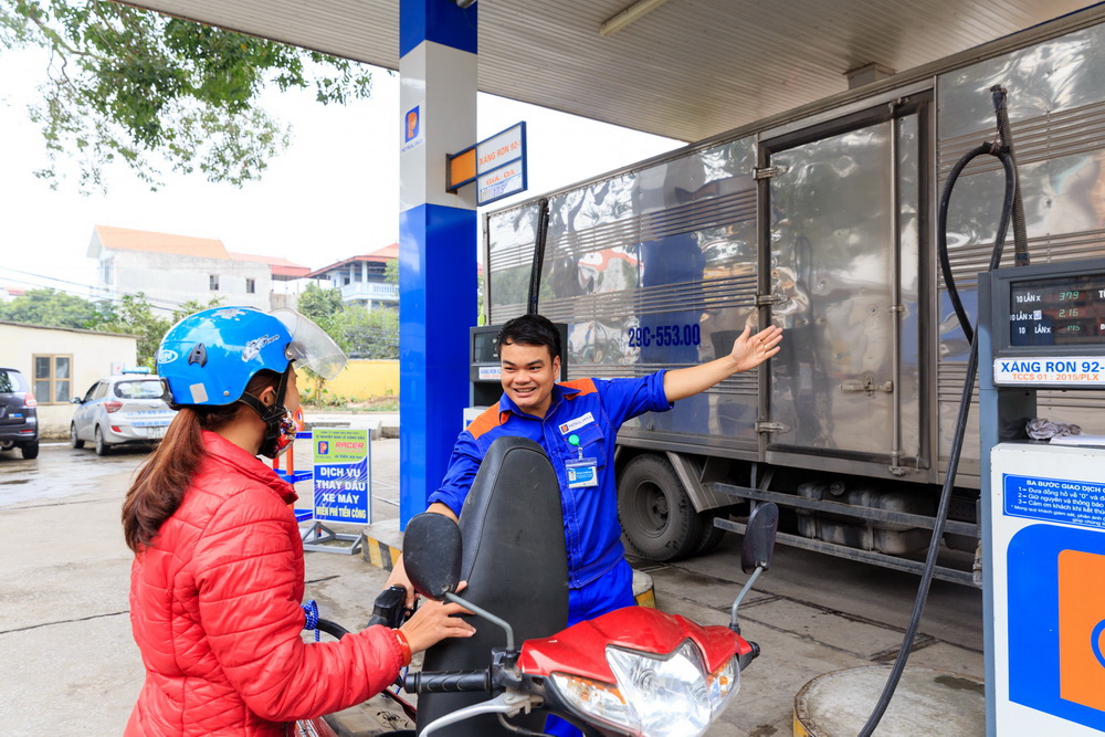 Nhân viên Petrolimex phục vụ khách tại cửa hàng xăng dầu — mạng lưới ~5.500 điểm bán lớn nhất nước. Ảnh: Tuổi Trẻ.